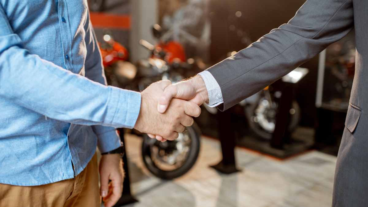 A salesman closing a deal for a title loan on a motorcycle.