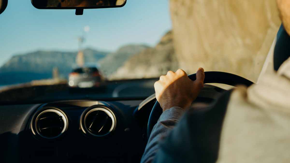 A man driving a car thinking about using it as collateral for a loan.